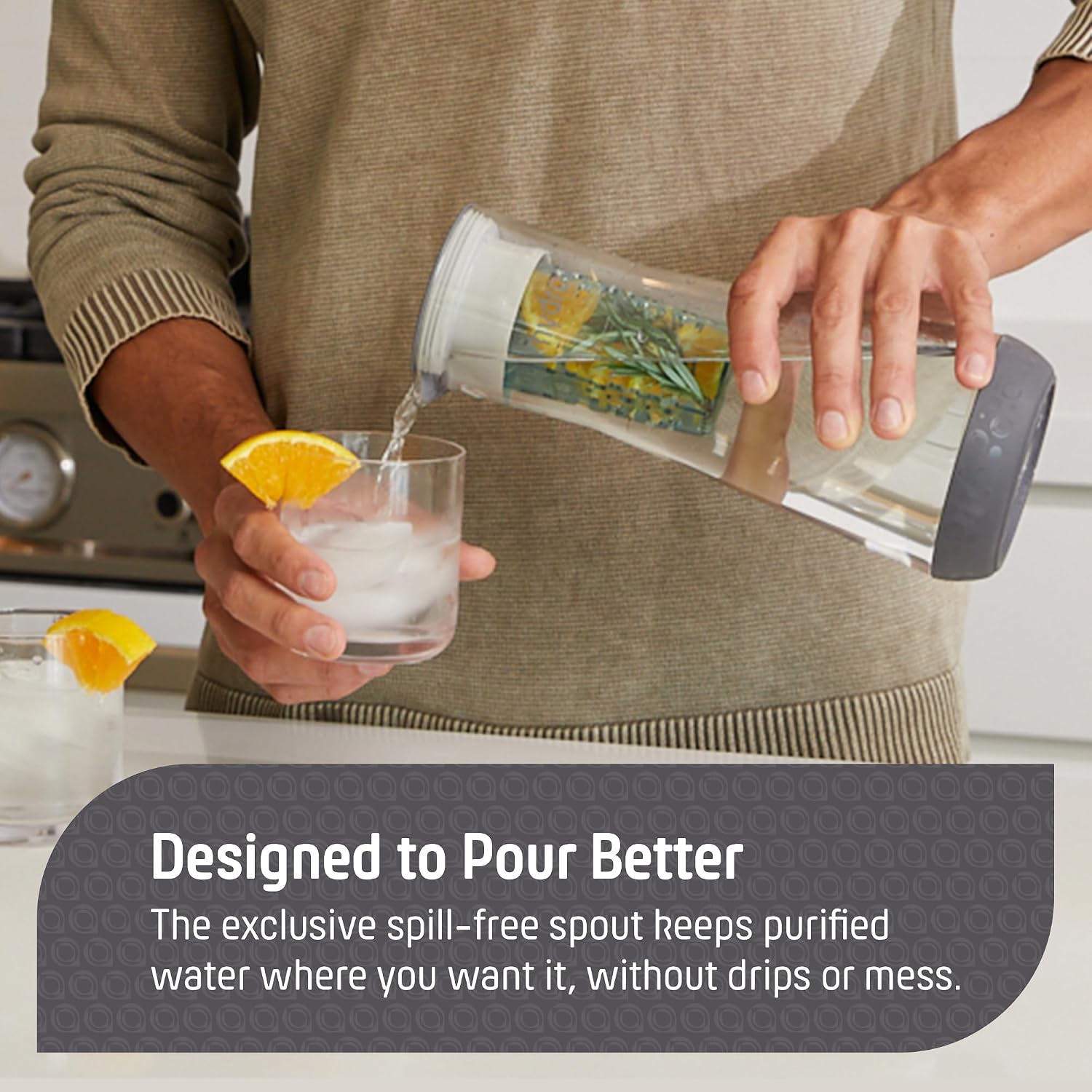 Person pouring water from a clear pitcher into a glass with ice and a lemon wedge, with text about spill-free spout design.